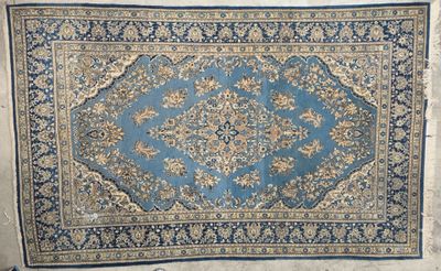 un tapis bleu et beige orné d'un motif en médaillon