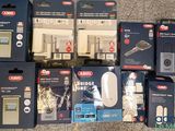 Plusieurs cartons contenant des gadgets électroniques sont posés sur un sol carrelé.