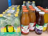 several bottles of juice sit on a shelf in a store
