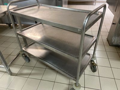 a metal cart that is on the floor in the kitchen