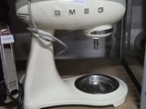 a white mixer sitting on a shelf in a kitchen