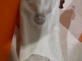 un sac blanc orné d'un logo, posé par terre
