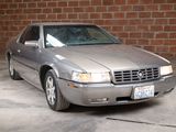 a silver car that is parked in front of a brick wall