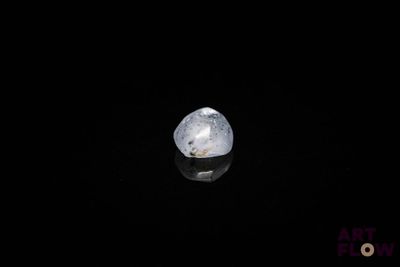 a close up of a white diamond on a black surface
