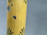 a close up of a yellow vase with a black lid