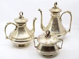 deux théières en argent et une soucoupe sur fond blanc