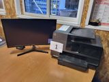 two computer monitors on a desk with a printer on it