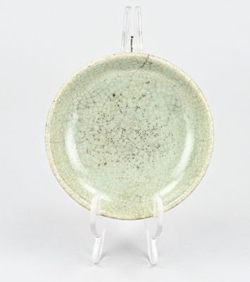assiette verte avec un fond blanc, posée sur un support, sur un fond blanc