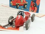 a red toy car sitting on top of an open book