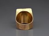 an image of a gold ring on a gray surface
