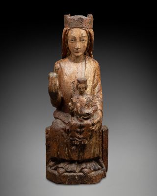une statue en bois représentant une femme tenant un enfant