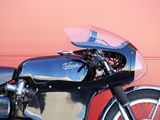 a black motorcycle parked in front of a red wall