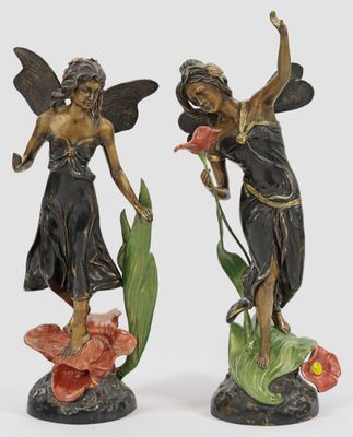 deux figurines représentant deux femmes ailées entourées de fleurs