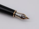 a close up of a fountain pen on a white surface