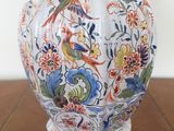a vase that has a bird on it on a table