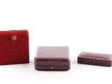 trois pièces en cuir rouge avec un fermoir doré et un étui rouge