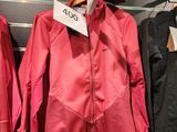 trois vestes suspendues à un portant dans un magasin