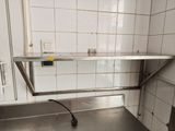 a stainless steel counter in a kitchen with tile on the walls