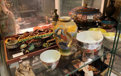 une vitrine en verre dans laquelle sont exposés de nombreux vases de styles variés