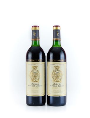 deux bouteilles de vin posées l'une à côté de l'autre sur une surface blanche