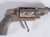 un vieux pistolet posé sur une surface blanche