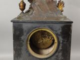 une statue de femme assise au sommet d'une horloge