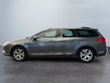 the grey car is parked in a large room with a white wall