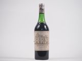 une vieille bouteille de vin posée sur une table blanche