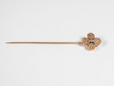 un gros plan d'une broche en or ornée d'une fleur