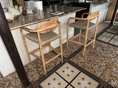 deux tabourets en bois posés dans une cuisine, à côté d'un plan de travail