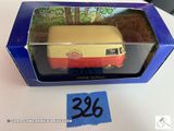 une boîte contenant un petit bus en jouet, posée sur une table