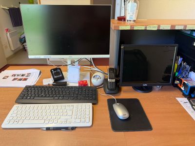un bureau sur lequel se trouvent un ordinateur, un clavier, une souris et un téléphone portable