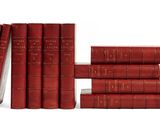 des livres rouges empilés les uns sur les autres sur une surface blanche