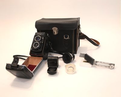 un sac noir sur lequel se trouvent un appareil photo et d'autres objets