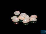 some white oplites are sitting on a black surface