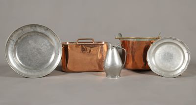 trois types différents de casseroles et poêles en cuivre posés sur une table