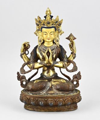 une statue en bronze représentant un Bouddha tenant un serpent dans ses mains