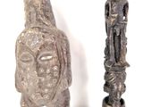 deux statues assises l'une à côté de l'autre sur une surface blanche