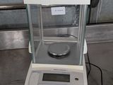 an electronic scale sitting on top of a metal counter top