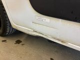 a close up of a white truck with dirty paint on it