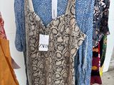 three women ' s shirts hanging on a rack in a clothing store