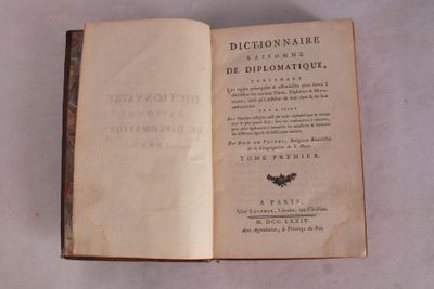 un livre ouvert posé sur une table, sur fond blanc