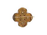 an image of a gold and red broochle with a cross on it