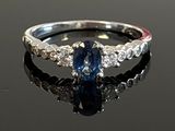 an image of a blue sapphire and diamond ring on a black surface