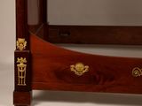 a bed with a wooden frame with gold decorations on it
