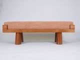 a wooden bench with a tan upholstered seat and legs