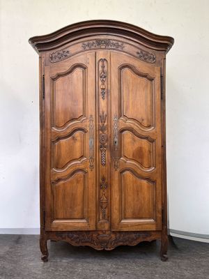 une vieille armoire en bois avec un dessus sculpté et deux portes
