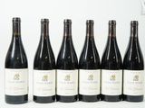 six bouteilles de vin sont alignées sur une surface blanche