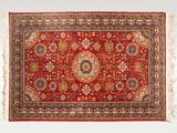 un tapis rouge orné d'un motif en médaillon et de franges