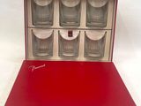 four shot glasses in a red box on a white background